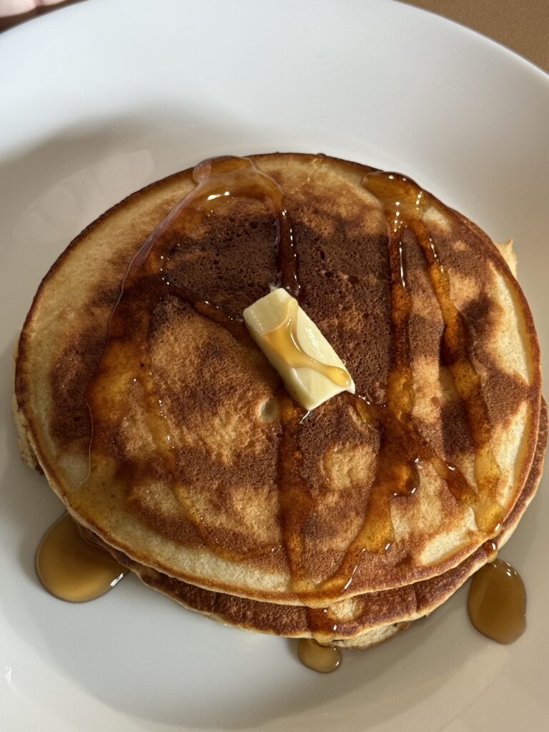 stacked pancakes with maple syrup and butter